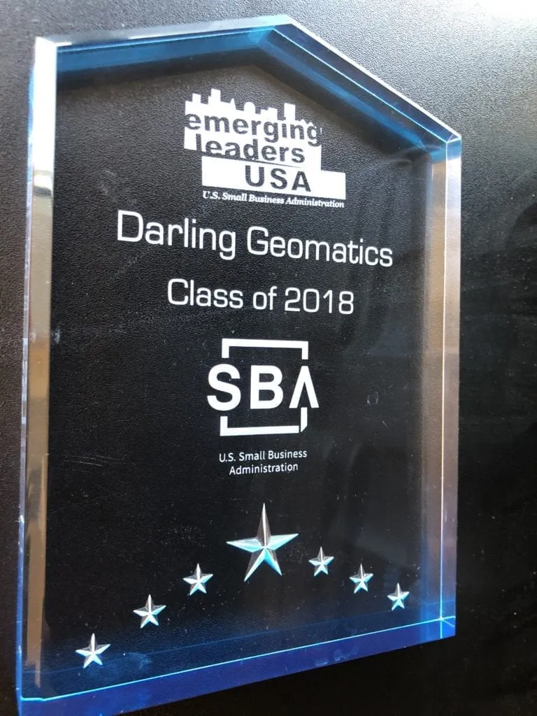 award crystal trophy on a black background, the text on the plaque says "emerging leaders USA, Darling Geomatics, Class of 2018, US Small Business Administration